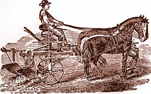 A farmer sits as his horses pull.